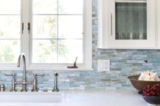 21 white cabinets, small blue tiles all over and white quartz countertops