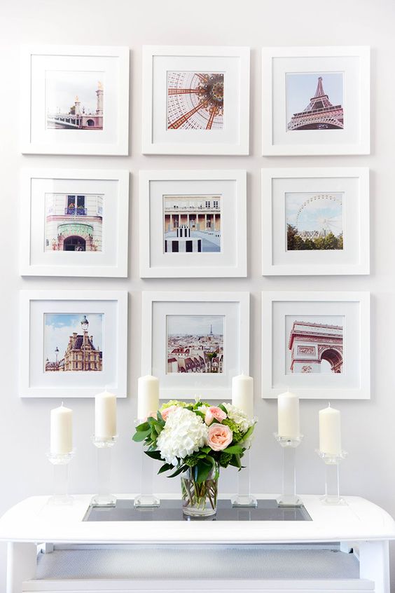 light filled and sweet photo gallery wall with pics from trips, all of them in white frames and of the same size