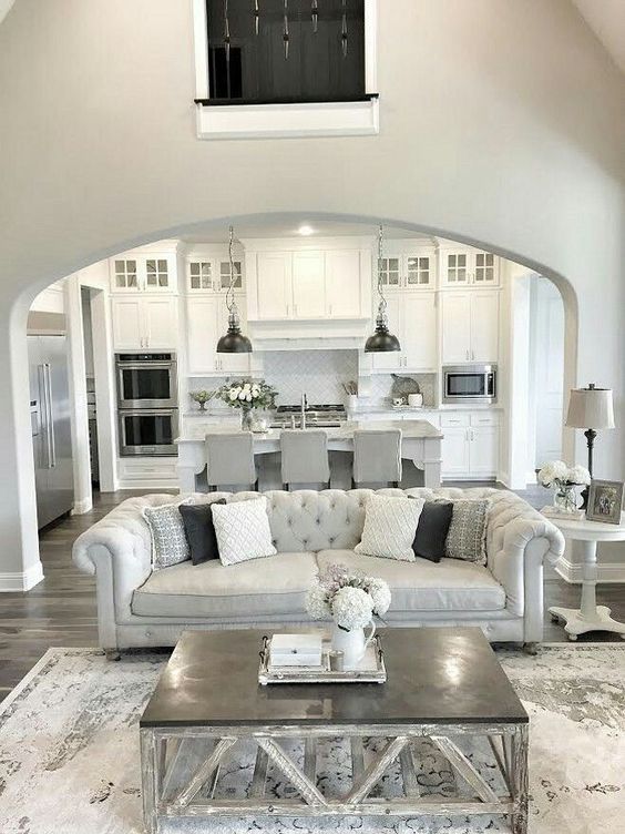all-white kitchen with greys and a grey and silver living room with an open plan