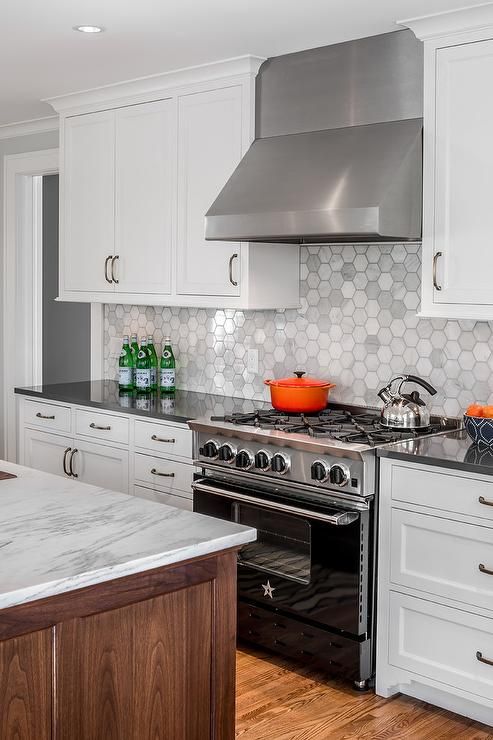 25 white cabinets accented with oil rubbed bronze pulls and a charcoal gray quartz countertop