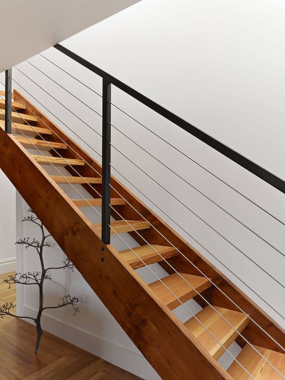 warm wood staircase with metal posts, metal and cable railing, which loooks almost invisible