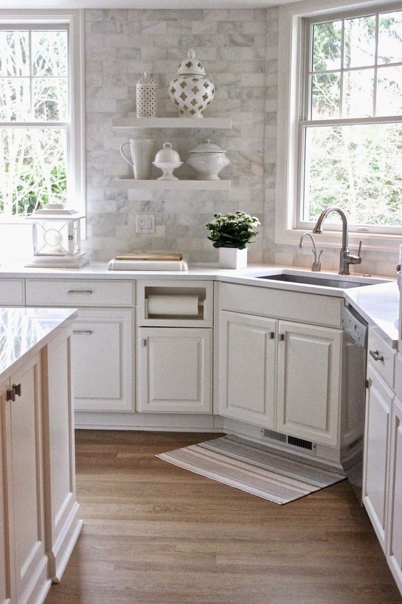 white cabinets, subway tiles with a Carrara marble print, white quartz countertops