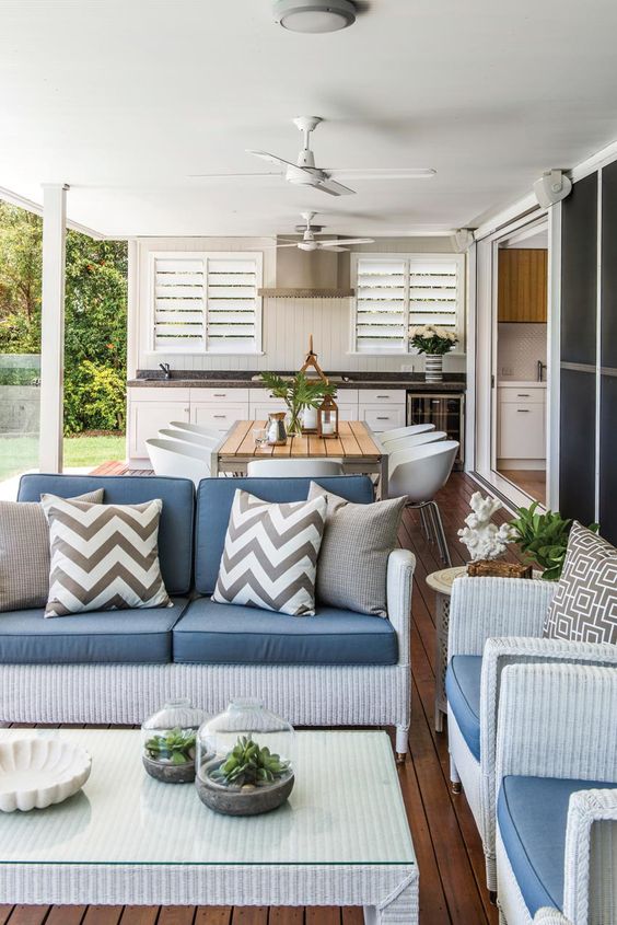 seaside living room with wicker furniture and a calm white kitchen with a black countertop
