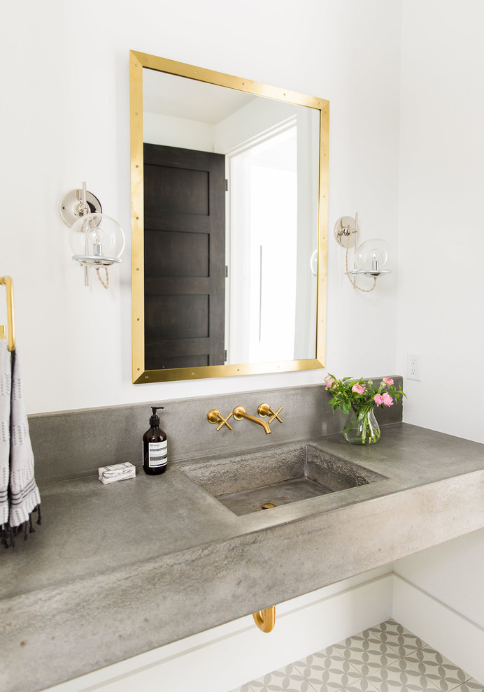 Gold bathroom fixtures looks amazing on concrete. (Studio McGee)