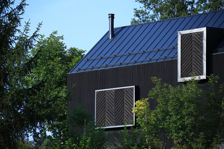 Compact and monolithic exterior appearance of the lodge with dark wooden shutters