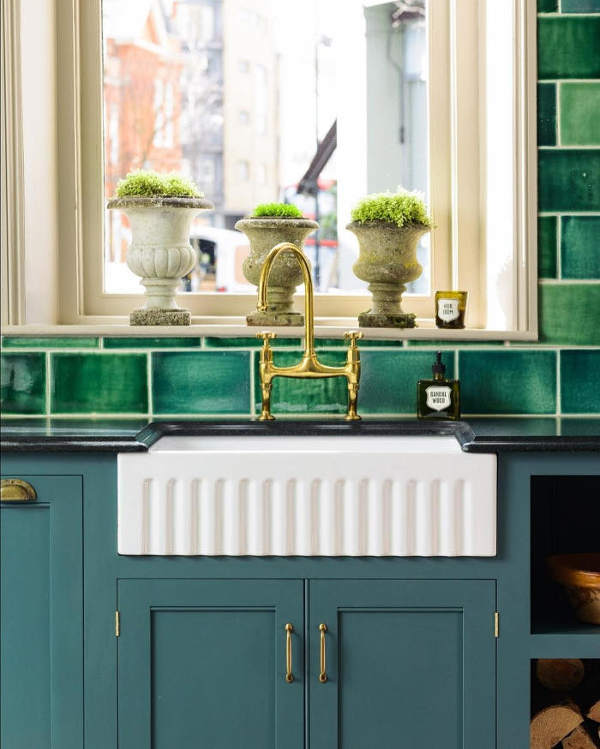 The blue cabinets with copepr handles look elegant and traditional, and stone urns are used instead of usual pots The blue cabinets with copepr handles look elegant and traditional, and stone urns are used instead of usual pots