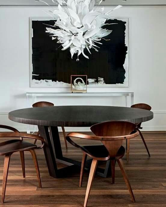 this round dark dining table makes a bold statement and everything is centered around it