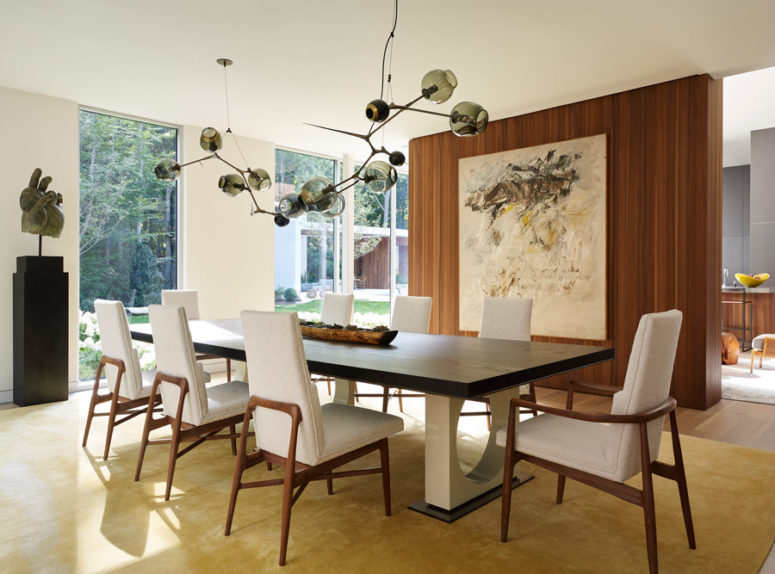 The dining space is a comfy one with upholstered chairs and a stunning dark glass chandelier