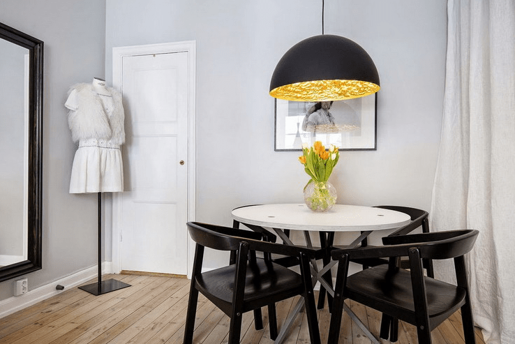 The dining space is done with black chairs and accentuated with a black and gold Tom Dixon pendant lamp The dining space is done with black chairs and accentuated with a black and gold Tom Dixon pendant lamp