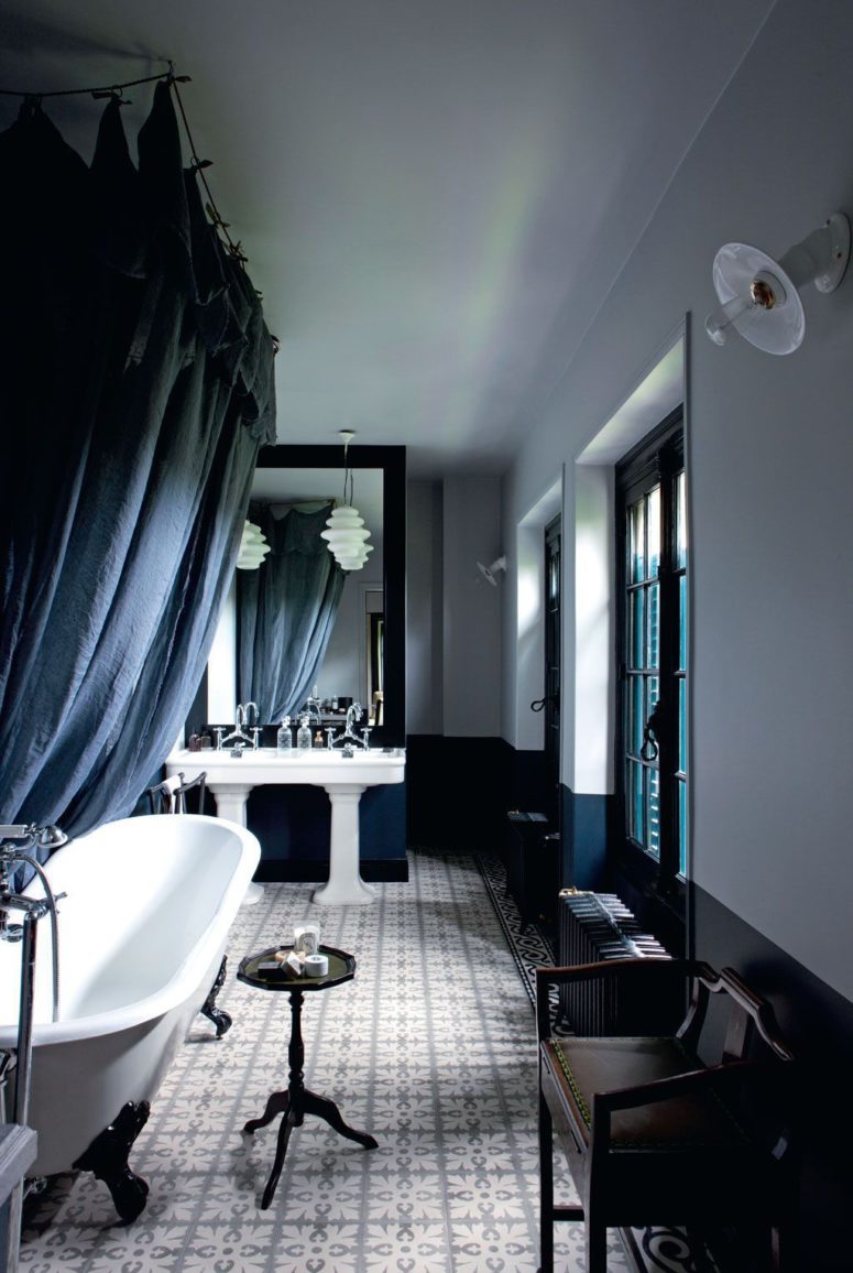 The master bathroom is refined, with teal, black and white and vintage sinks and a bathtub