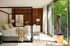 04 The master bedroom features a large framed bed, a geometric wall art and an antique sculpture