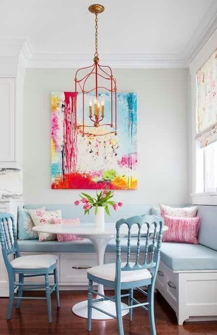 a small round white table matches a light blue upholstered bench and chairs