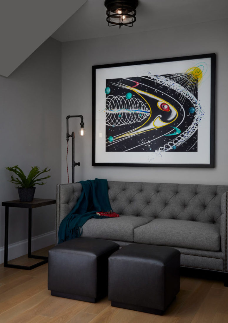 industrial pipes in a living room The living room features a comfy grey sofa and leather footrests, an industrial pipe lamp and a graffiti look awesome