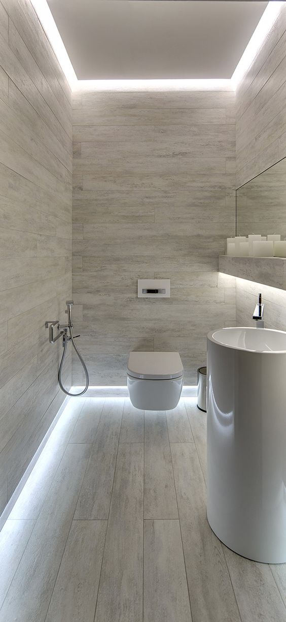 modern grey bathroom with floor light and a free-standing sink