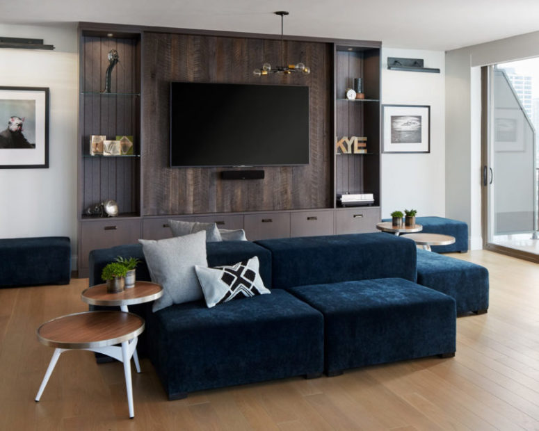 I totally love this navy velvet sofa with poufs that will accomodate all the guests, and a reclaimed wood TV unit with shelves