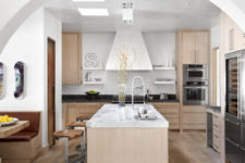 08 The kitchen is done in white and light-colored wood, I love the refined marble touches