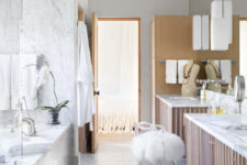 10 The master bathroom is clad with white marble and light-colored wood, I love glam accents