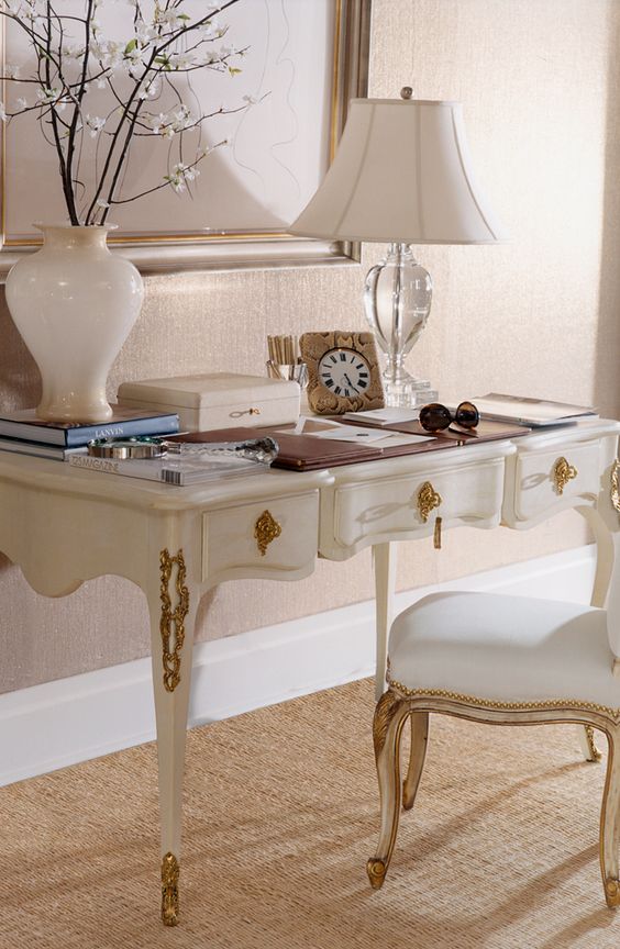 a refined white desk with gold details and a matching chair