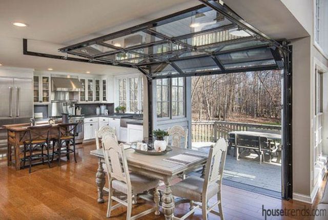 the dining space is opened to the deck with the help of garage doors