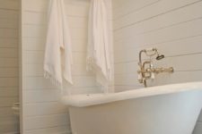 13 slipper clawfoot tub on white legs in a modern bathroom with vintage touches