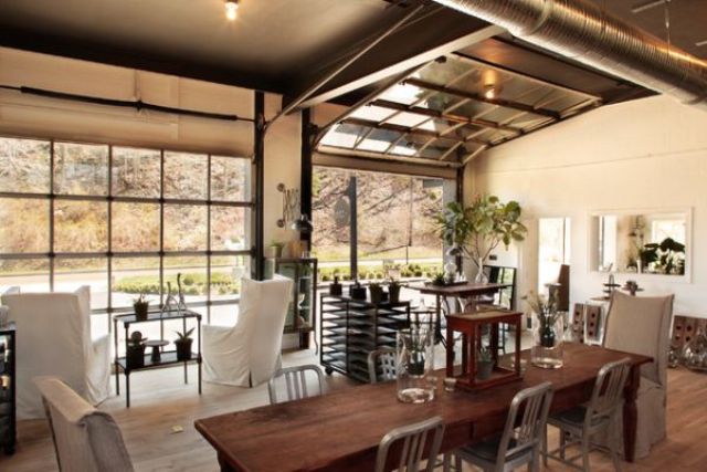 a sectional glass garage door used in an eclectic living room with adjacent outdoor spaces