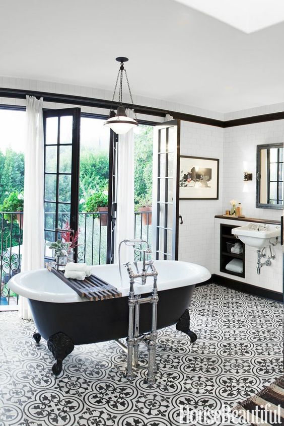 20s inspired bathroom in black and white with an oval black clawfoot tub on legs