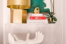 18 console table styled with a sculpture, a gold lamp and an oversized wall art