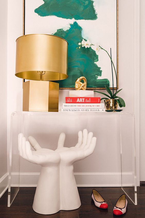 console table styled with a sculpture, a gold lamp and an oversized wall art