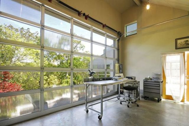 a giant glass garage door opens the home office to the lake outside