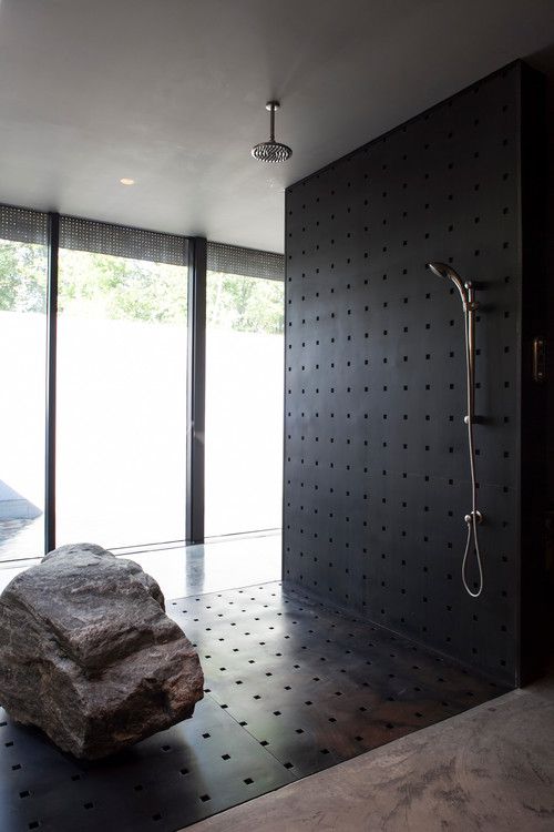 perforated metal shower with a real rock piece inside it