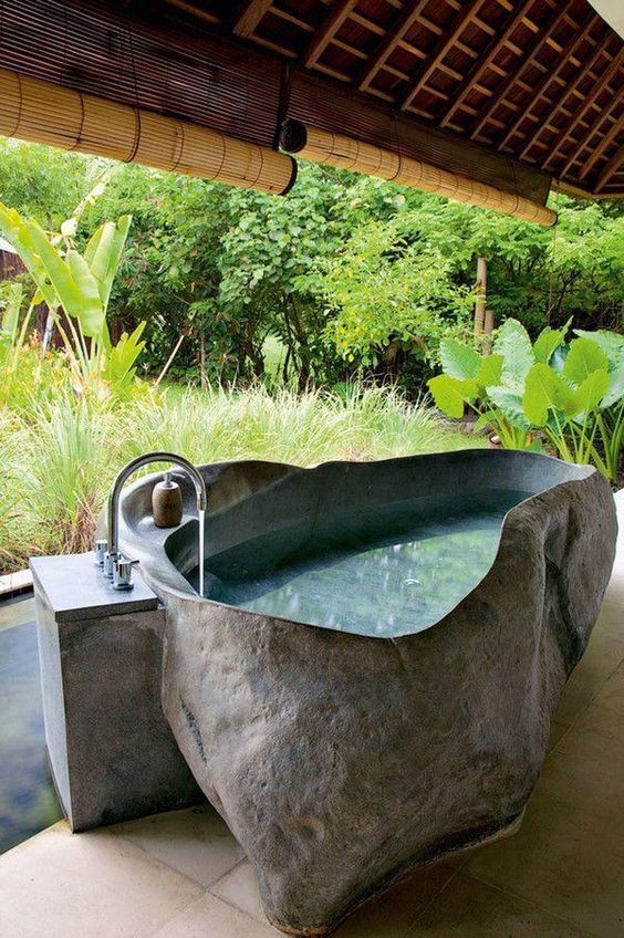 outdoor bathroom with an irregular shaped stone bathtub with a raw edge makes you feel like in an oasis