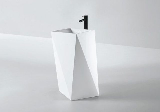 white sculptural faceted sink with a black faucet for a modern bathroom