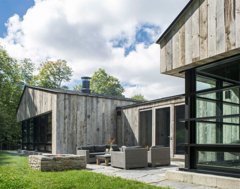 The house consists of two buildings and there's a terrace with a fire pit between them