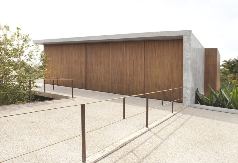 The house outside is clad with slatted wood and concrete for a contrast, and it stands out in the rainforest The house outside is clad with slatted wood and concrete for a contrast, and it stands out in the rainforest