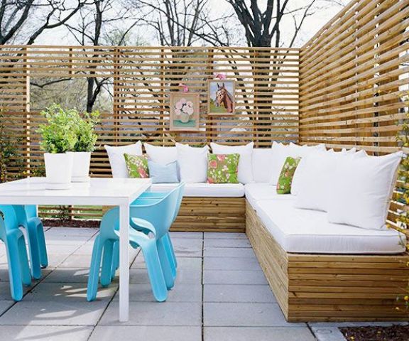 light-colored wood bench with storage echoes with privacy screens around and creates a chic space