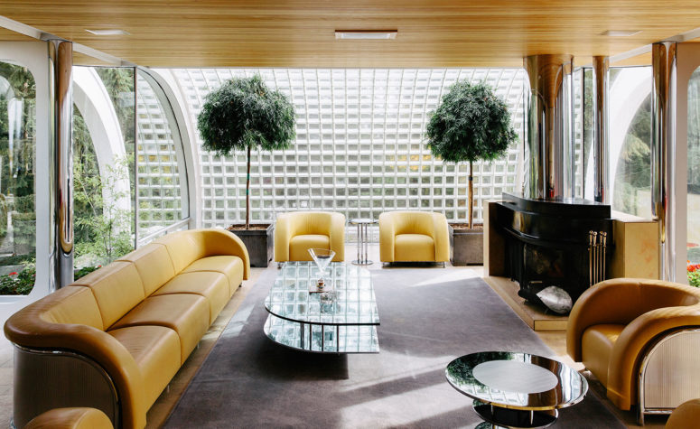living room with a coffee table The curved lines of the living area's seating, coffee table and fireplace mimic the form of the house