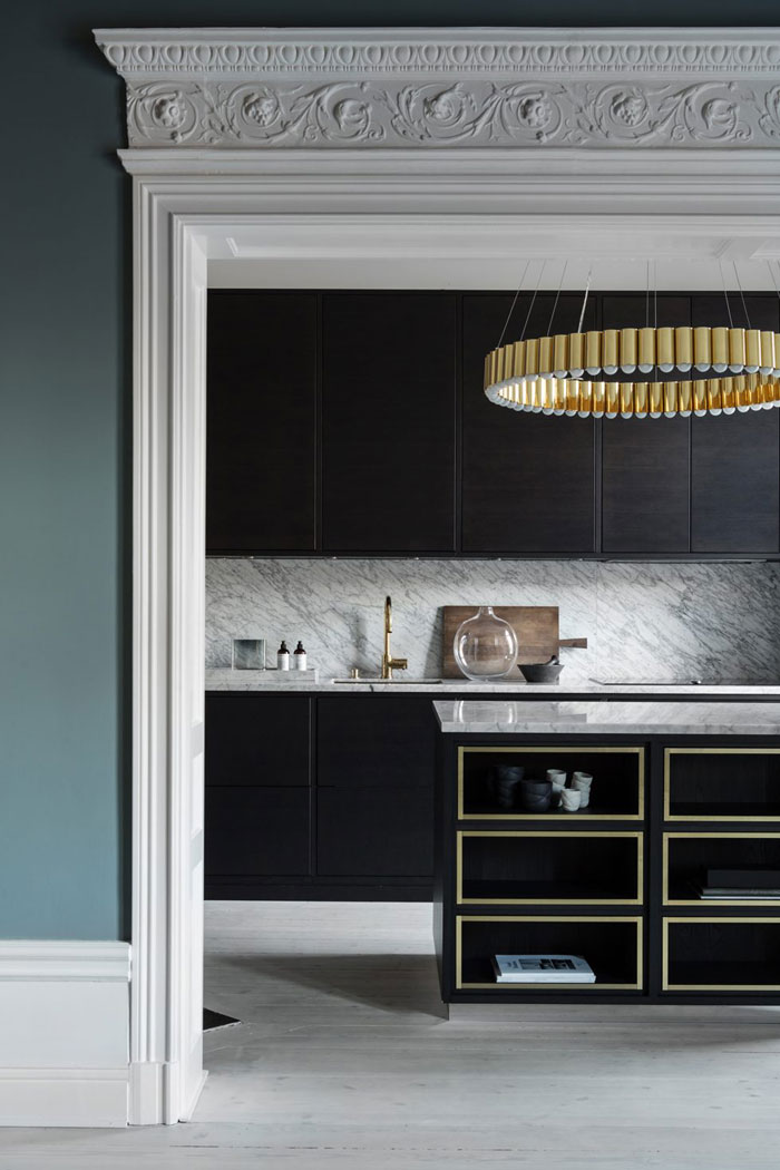The kitchen is very refined, with dark stained cabinets, brass chandeliers and gilded frame kitchen island The kitchen is very refined, with dark stained cabinets, brass chandeliers and gilded frame kitchen island