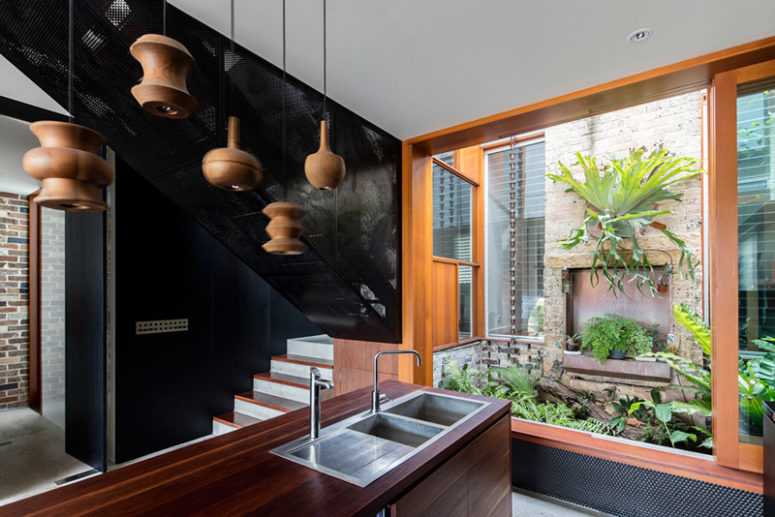 The wooden kitchen island is lit up with similar lamps and there's a semi patio with lots of greenery right here The wooden kitchen island is lit up with similar lamps and there's a semi patio with lots of greenery right here
