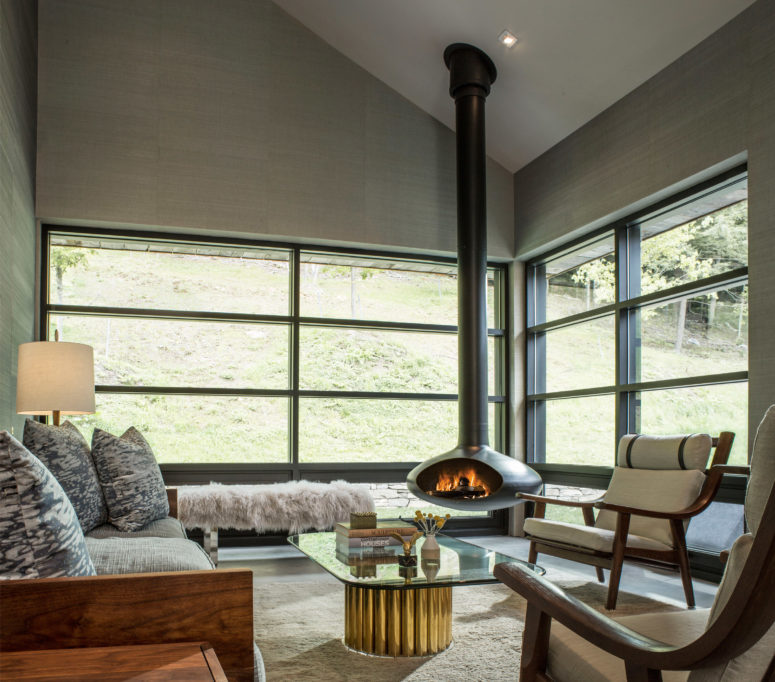 the living room is a glazed one, with a glass top table, with a hanging hearth and some upholstered furniture