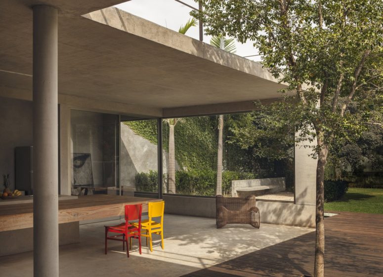 Here you'll see an outdoor dining space with a thick dining table and colorful chairs and floor-to-ceiling windows