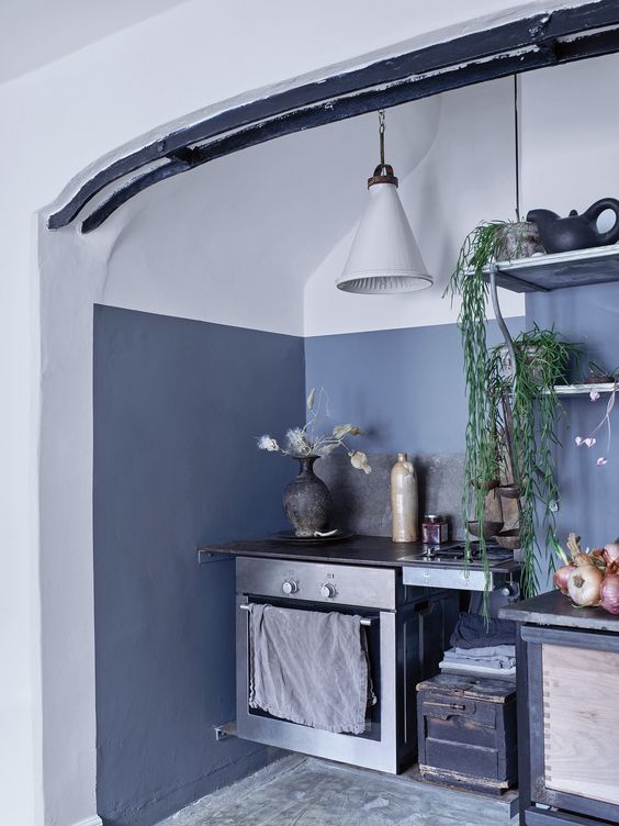 The kitchen is accentuated with asphalt grey, there's vintage furniture and appliances, and lamps are mid century modern The kitchen is accentuated with asphalt grey, there's vintage furniture and appliances, and lamps are mid-century modern