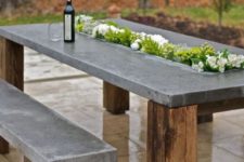 05 a concrete top table with wooden legs and a planter right in the center of the table