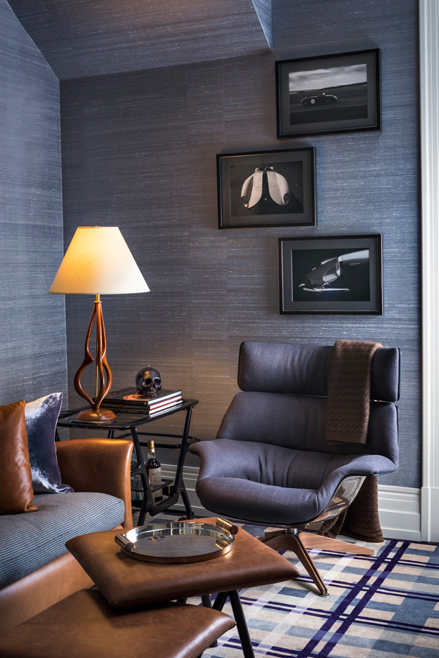 The corner is covered with dark fabric, with black and white photots and leather furniture, it's a manly space