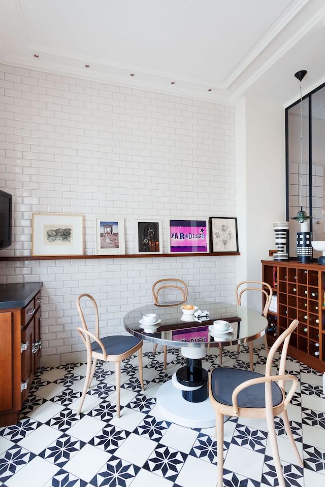 There's an arrangement of artworks and a mirrored table in the corner of the kitchen