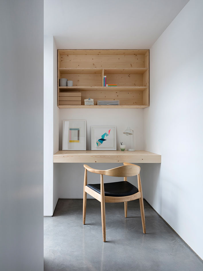 The workspace is with a built-in desk and a cabinet over it, everything is simple and laconic