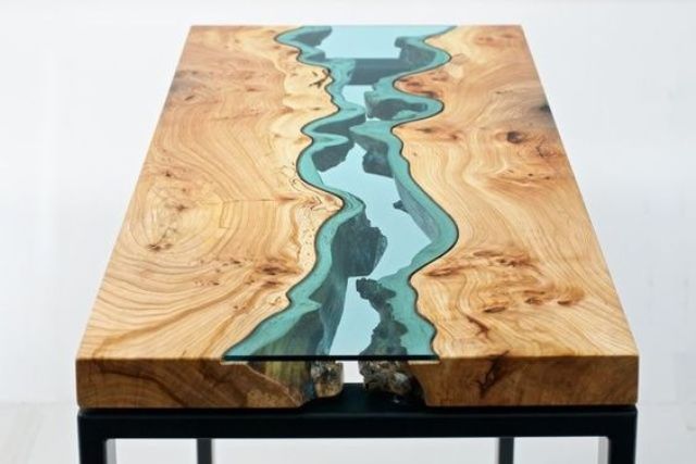 a wooden dining table with a blue glass insert that highlights its imperfections