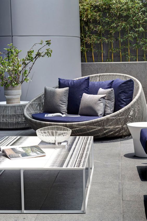 grey wicker love seat with navy cushions look great together
