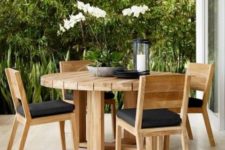 11 light-colored round wooden table with matching chairs and black upholstery