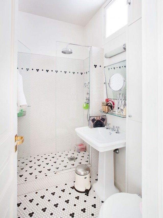 The bathroom is decorated with penny tiles in black and white