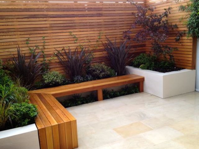 a fence echoes with the bench, which is surrounded with plants